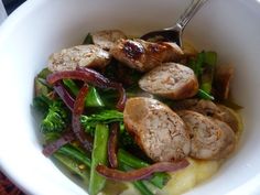 a white bowl filled with meat and veggies