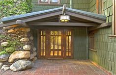 the front entrance to a home with stone and wood