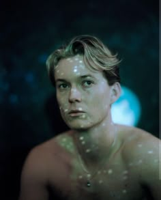 a man with no shirt on is looking at the camera while he's covered in bubbles