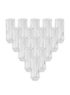 twelve clear glass candlesticks are lined up in a row on a white background