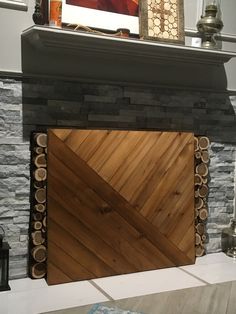 a fire place with wood logs on the mantle and a painting hanging over it's top