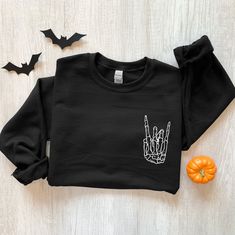 Halloween Shirt, Skeleton Rock Shirt, Halloween Skeleton T-Shirt, Skeleton Hand Halloween, Halloween Gift, Horror Shirt Sweatshirt Description Our graphic sweatshirts are very soft, very cute and bound to keep you warm in the colder months. It's a pre-shrunk, classic fit sweater made with air-jet spun yarn for a soft feel. ► SHIRT DETAILS The sweatshirts are UNISEX - they are meant to have a relaxed fit, please refer to the size chart for more details. * 8.0 oz., 50/50 cotton/polyester * Pre-shr Grunge Halloween Sweater For Streetwear, Black Long Sleeve Halloween Sweatshirt, Black Long Sleeve Sweatshirt For Halloween, Halloween Skull Print Sweatshirt For Streetwear, Black Grunge Sweatshirt For Fall, Halloween Streetwear Sweatshirt With Relaxed Fit, Halloween Grunge Long Sleeve Sweater, Black Halloween Graphic Print Sweatshirt, Black Long Sleeve Sweatshirt With Skull Print