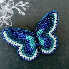 a blue and white beaded butterfly sitting on top of a table