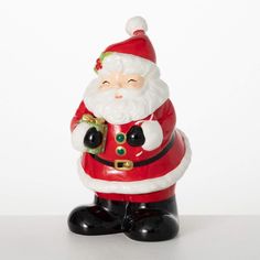 a santa clause figurine holding a christmas tree