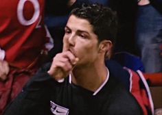 a man sitting in the stands with his hand to his mouth