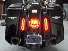 the back end of a black motorcycle with a skull on it's tail light