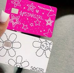 a hand holding a pink and white stargirl credit card