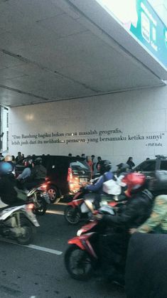 motorcycles parked in front of a building with words written on the wall above them and below it