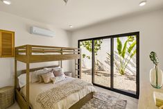 a bedroom with a bunk bed and sliding glass doors