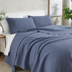 a bed with a blue bedspread and pillows