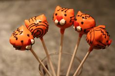 there are some cake pops decorated to look like tigers in the cupcakes on sticks