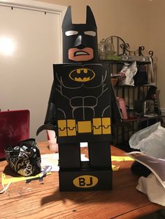 a lego batman standing on top of a wooden table