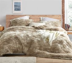 a bed with fluffy blankets and pillows in a bedroom