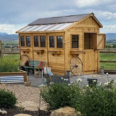 a small wooden building with a wheel on the front