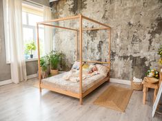 a bed sitting on top of a hard wood floor next to a wall covered in peeling paint