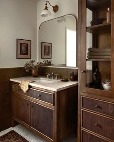 a bathroom with a sink, mirror and shelves on the wall next to each other