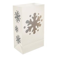 a white box with a candle inside and snowflakes on the side, sitting next to it