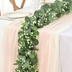 the table is decorated with greenery and white flowers