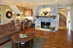 a living room filled with furniture and a fire place in the middle of a room