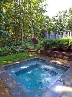 an outdoor hot tub in the middle of a garden