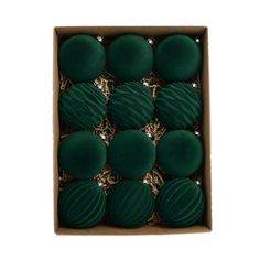 twelve green macaroni and cheese balls in a cardboard box on a white background