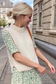 a woman walking down the street with her hand in her pocket