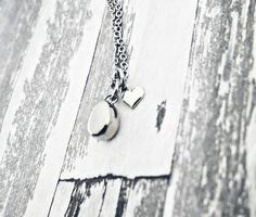 "Thos beautiful necklace is perfect for the minimalist. It features a 1/2\" teardrop pendant, which doubles as a mini urn so you can hold your loved one close to your heart at all times. The back unscrew so you can add ashes. Next to the urn is a tiny sterling silver heart charm. The chain and urn are stainless steel and will never tarnish. Each comes with a funnel and filling instructions. To see more urn jewelry please visit JessicaDennisDesigns.etsy.com" Silver Minimalist Charm Necklace For Keepsake, Silver Teardrop Necklace With Heart Charm, Sterling Silver Teardrop Charm Necklace For Anniversary, Sterling Silver Teardrop Pendant Charm Necklace For Anniversary, Minimalist Teardrop Charm Necklace For Anniversary, Minimalist Teardrop Charm Necklaces For Anniversary, Anniversary Sterling Silver Teardrop Pendant Charm Necklace, Anniversary Sterling Silver Teardrop Charm Necklace, Cremation Necklaces