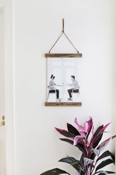 a potted plant sitting on top of a wooden table next to a white wall