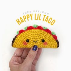 a hand holding a small crocheted taco with the text free pattern happy lil taco on it