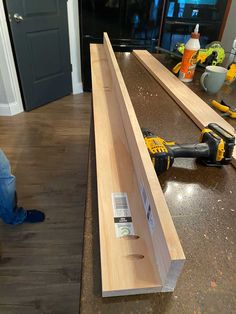 a man is working on a piece of wood with a power drill and screwdriver