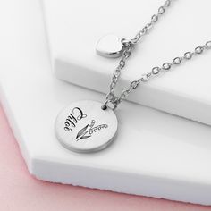 Treat her to a stylish and meaningful gift with our beautiful Personalised Birth Flower Brushed Heart and Disc Necklace. With its unique design, this necklace is perfect for any occasion. Whether you gift it to your mum this Mother’s Day, your girlfriend on Valentine’s or treat a loved one on their birthday, this outstanding piece of women’s jewellery will make the perfect gift for her. Personalise with your loved one’s name and their birth flower - both will be meticulously engraved onto the pendant by our personalisation exports - creating a truly one-of-a-kind gift that will hold real sentimental value to her. Alongside this will be a cute little heart pendant, representing your love - she’ll forever hold it close to her heart. Your necklace will come beautifully nestled inside in a sle Mother's Day Stainless Steel Necklace For Mom, Mother's Day Gift Stainless Steel Necklace, Valentine's Day Stainless Steel Necklace Gift For Mom, Stainless Steel Necklaces For Mom On Valentine's Day, Valentine's Day Gift For Mom: Stainless Steel Necklaces, Valentine's Day Gift For Mom: Stainless Steel Necklace, Heart-shaped Charm Necklace With Flower For Gift, Heart-shaped Flower Charm Necklace For Gift, Mother's Day Gift Round Charm Necklaces