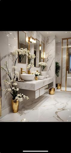 a bathroom with two sinks, mirrors and flowers in vases on the counter top