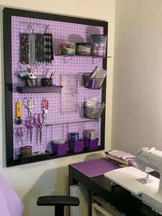 a sewing machine sitting on top of a table next to a wall mounted pegboard