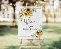 a welcome sign with sunflowers and greenery