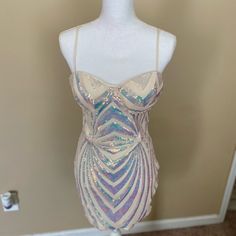 a mannequin wearing a white and purple dress with sequins on it