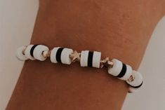 a person wearing a bracelet with black and white beads