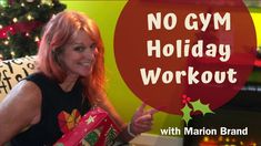 a woman with red hair holding a christmas present in front of a fire place and sign that says no gym holiday workout