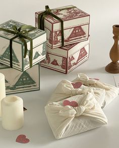 three boxes and two candles on a table