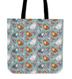 a blue tote bag with cats and flowers on the front, one cat is sitting in