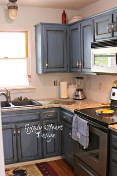 a kitchen with blue cabinets and silver appliances