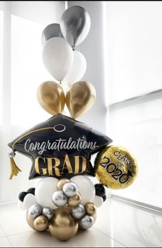 graduation balloon arrangement with congratulations graduate's cap and gold, silver and white balloons