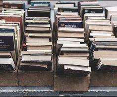 several stacks of books are stacked on top of each other in different colors and sizes