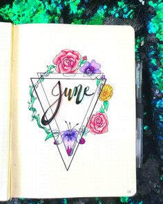 an open notebook with the word june written in cursive writing and colorful flowers