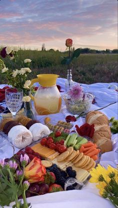 a table topped with lots of different types of food and flowers on top of it