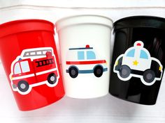 three cups with different designs on them sitting next to each other, one has a firetruck and the other has a police car