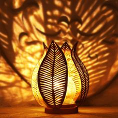 a lamp that is sitting on top of a wooden stand with a shadow cast on the wall behind it