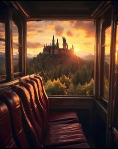 the sun is setting over hogwarts castle as seen from an empty train car