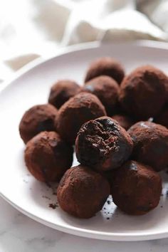 a white plate topped with chocolate truffles on top of a table