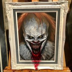 a painting of a creepy clown with red hair and fangs on it's face