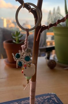 a close up of a keychain on a table next to a potted plant